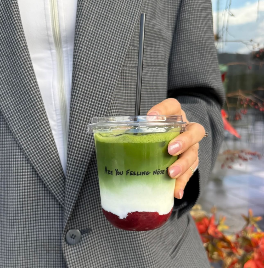 lady holding ice strawberry matcha from noje tirana wearing a blazer